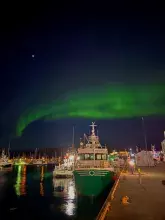 Zdjęcie statku badawczego w porcie, na tle zorzy polarnej, Norwegia